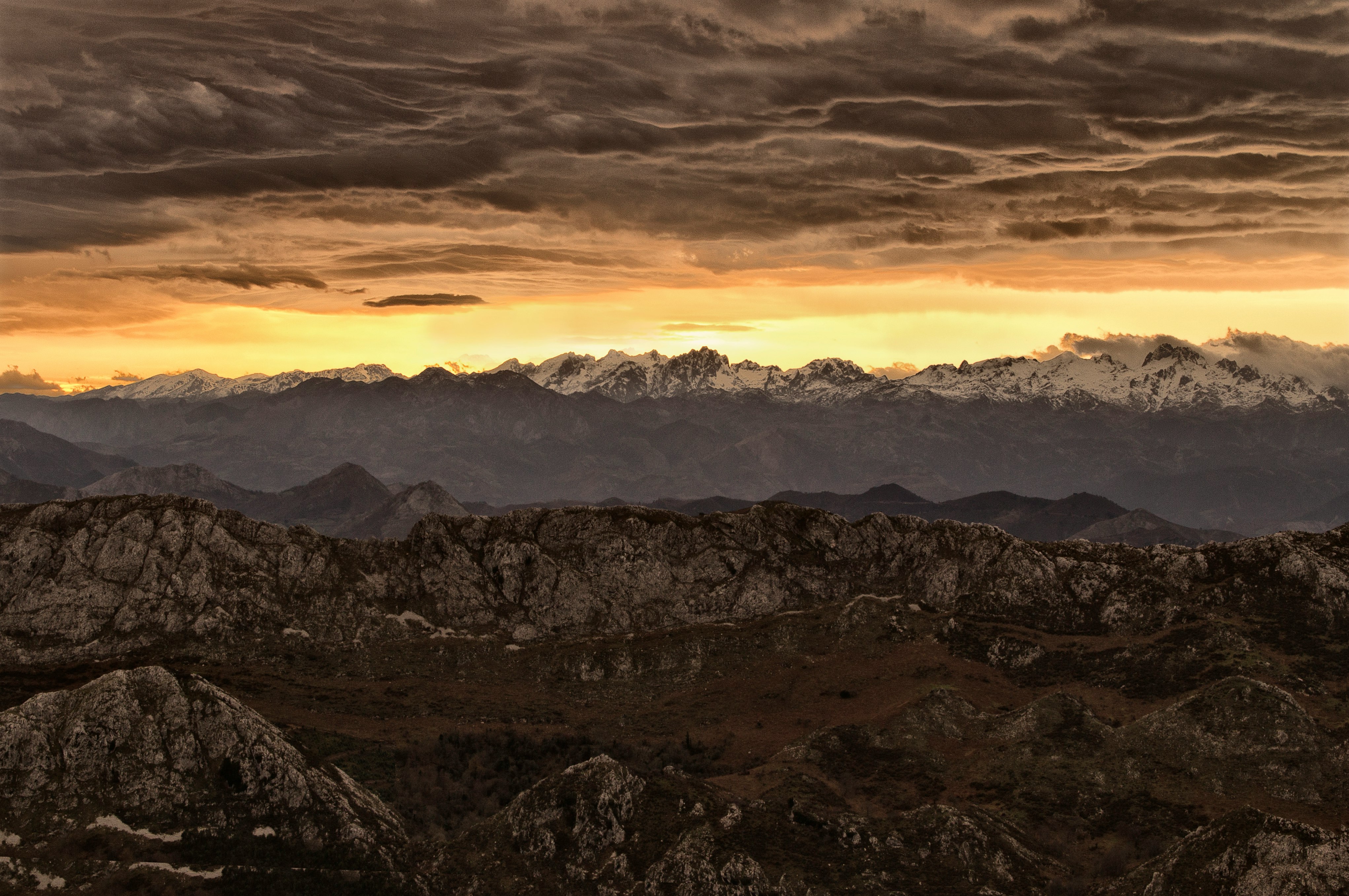 mountain under cloudy sky during sunset